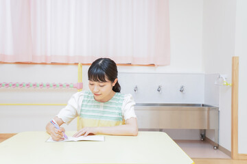 Young kindergarten teacher working at office
