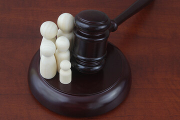 Family court concept. Judge gavel with many wooden figures of family.