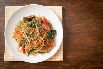 japchae or stir-fried Korean vermicelli noodles with vegetables and pork topped with white sesame