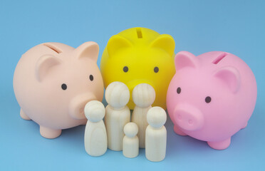 Family savings, economy and family budget concept. Three different piggy banks and family people figures on blue background.	