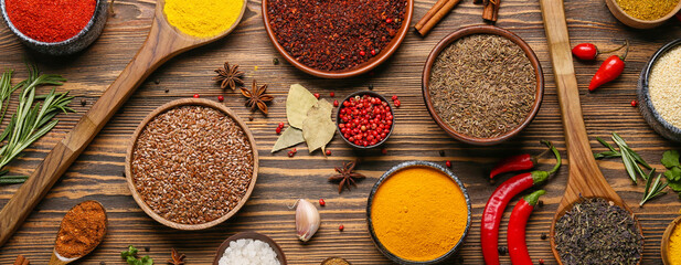 Set of different spices on wooden background, top view