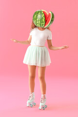 Beautiful young woman on roller skates with ripe watermelon instead of her head against pink background
