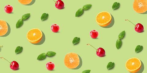 Oranges, berries and mint on green background. Pattern for design