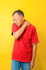 Asian Elderly man experiencing shoulder pain  and neck pain isolated on yellow background