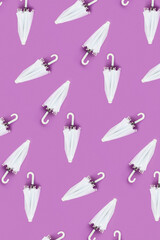 Many white umbrellas on lilac background. Pattern for design