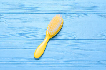Baby hair brush on color wooden background