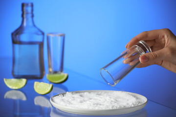 Woman preparing shot for tasty mexican tequila on color background