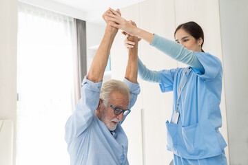 Female nurse physical therapy elderly man at hospital ward. Asian female nurse caring elderly man...