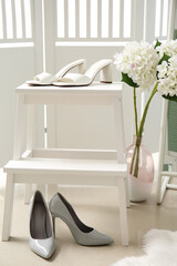 Step ladder with stylish female shoes and beautiful flowers in room
