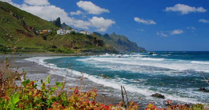 Sandy Almaciga beach, mountain coastline in the north of Tenerife. Cute colourful village, Spain. Roque de las Animas. Local vegetation.