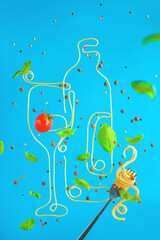 Pasta drawing, wine bottle and glass made out of spaghetti, basil leaves and tomatoes