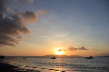 Beautiful view of sunrise on the beach with silhouettes people on the waterfront. Great for Background. 