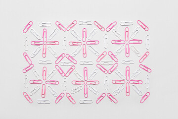 Pink and white paper clips on light background