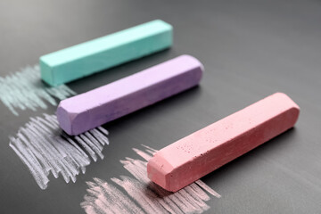 Colorful chalks on school blackboard, closeup