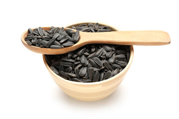Wooden bowl and spoon with unpeeled sunflower seeds on white background