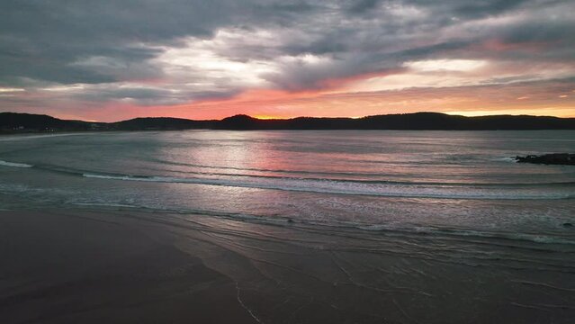 A mix of high and medium cloud put on a colourful display for sunrise at Umina Point, Umina Beach on the Central Coast, NSW, Australia.