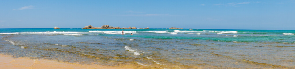 Fototapeta na wymiar Hikkaduwa, Sri Lanka - March 8, 2022: Panoramic view of the Indian Ocean with azure water at low tide near the coral reef of Hikkaduwa beach. Copy space