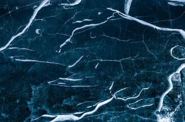 Aerial shot of ice cracks in Juriver lake in winter