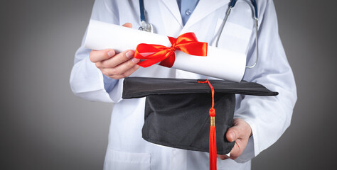 Caucasian doctor holding graduation hat and diploma. Medical education
