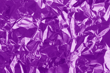 Purple foil texture background, pattern of violet wrapping paper with crumpled and wavy.
