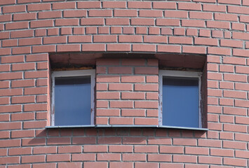 Fragment of the facade of a brick building on a summer day