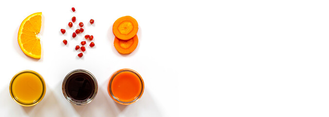 three kinds of juices orange, pomegranate, carrot on a white surface, carrot and orange slices, pomegranate seeds, top view, healthy food concept, vitamin detox, diet