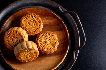 Mooncakes in a vintage tray Chinese festive snacks on black background