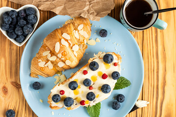 classic american breakfast. Fresh french croissant with fresh berries. blueberry and strawberry on...