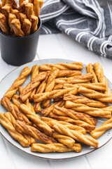 Salted pretzel sticks. Salted crackers on plate.