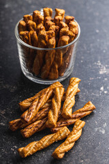 Salted pretzel sticks. Salted crackers on black table.