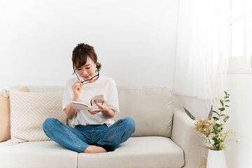Fototapeta premium 読書中に眼鏡を直すおしゃれな日本人女性（メガネ） 