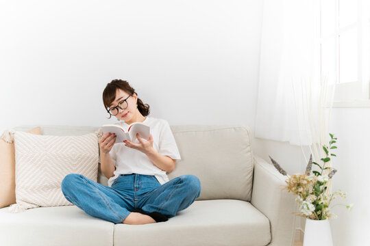 家で読書してダラダラする日本人女性（悩む）
