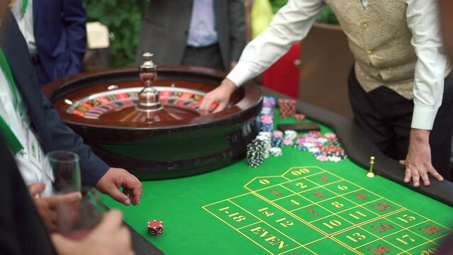 A table with a roulette in a casino. The croupier gives out a prize. Gambling for money. People make bets on roulette. Underground Casino. High quality FullHD footage