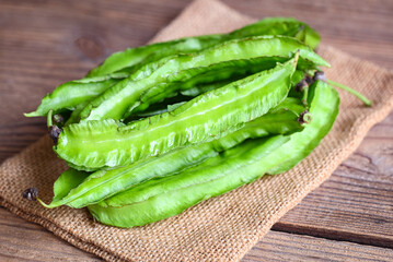 Winged Bean on sack background, Psophocarpus tetragonolobus - Green winged or Four angle beans - 512266913