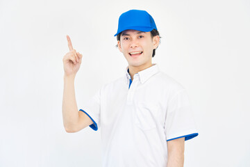 左側を指差すキャップとポロシャツのユニフォームの男性