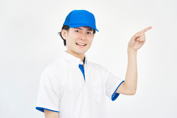 右側を指差すキャップとポロシャツのユニフォームの男性