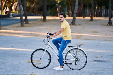 Happy man smiling while enjoying a ride on a bike outdoors. Transport and urban lifestyle concept.