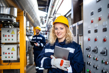 Portrait of female engineer or supervisor standing in factory interior.