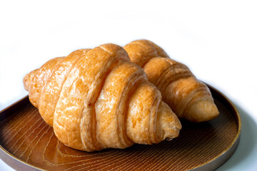 two croissants in a plate on white background.