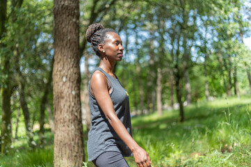 Naklejka premium Young woman hiking, walking in the woods on a sunny day