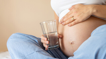 Pregnant drinking water. Young pregnancy mother drink water. Pregnant lady waiting of baby. Glass of water. Concept maternity, childbirth.