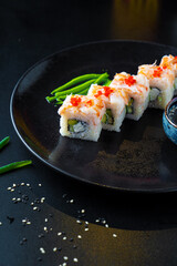 Traditional Asian rolls and sushi with soy sauce and wasabi served on a dark background