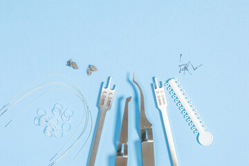 a set of special tools for an orthodontist to install braces for a patient. Orthodontic arcs, ligature, locks, positioner, tweezers