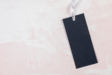 Clothing tag, label blank mockup template on a marble pink table