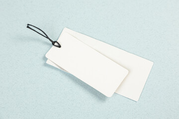 Empty white price tag on a gray-blue background with a soft shadow