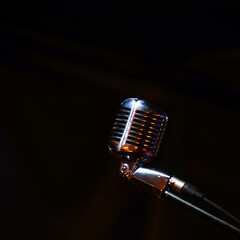 Shiny retro microphone on a black background. Soft focus