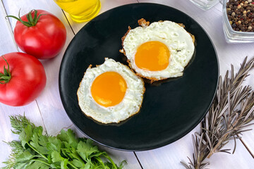 Fried eggs with vegetables, spices and herbs on light wooden background. Traditional European or Asian breakfast. - 512277799