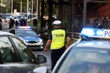 Oznakowany  radiowóz Samochód polskiej policji na sygnałach w czasie akcji na ulicy w mieście.  © FotoDax