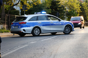 Wieczorem w mieście radiowóz policyjny na sygnałach i syrenie jedzie z pomocą. 