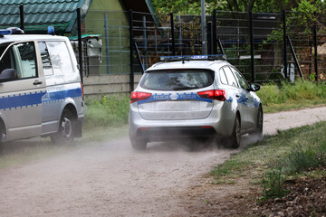 Oznakowany  radiowóz Samochód polskiej policji na sygnałach w czasie akcji na ulicy w mieście.  - obrazy, fototapety, plakaty